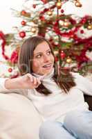 Young woman sitting in front of Christmas tree