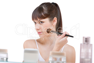 Body care: Young woman applying powder with brush