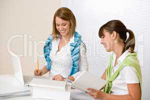 Student at home - two woman with book and laptop