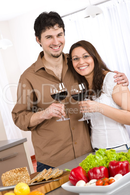 Happy couple drink red wine in modern kitchen