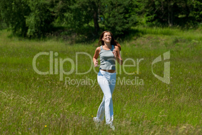 Young smiling woman jogging in the nature