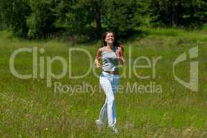 Young smiling woman jogging in the nature