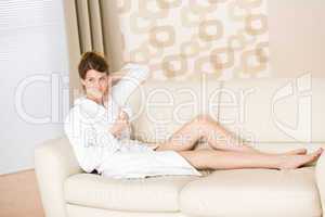 Young woman in white bathrobe with coffee