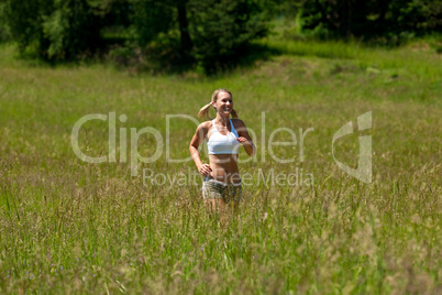 Young woman jogging in a meadow