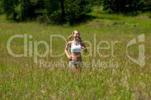 Young woman jogging in a meadow