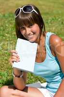 Happy young woman with book in park