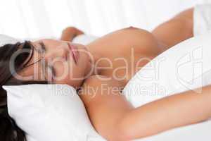 Brown hair woman sleeping naked in white bed