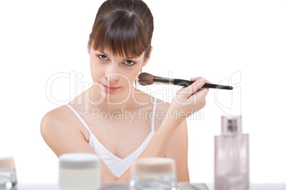 Body care: Young woman applying powder with brush