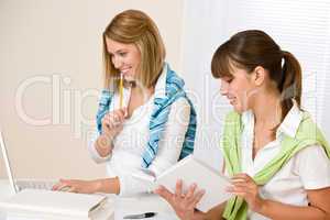 Student at home - two woman with book and laptop