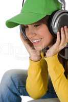 Happy female teenager enjoy music with headphones