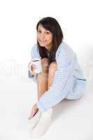 Happy young woman with coffee in pajamas