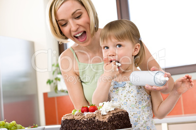 Mother and child with chocolate cake in kitchen