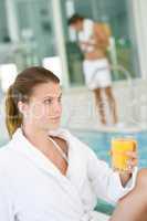 Young woman relax at swimming pool, drink juice