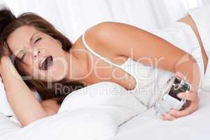 Tired woman waking up and yawing