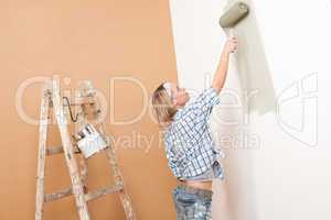 Home improvement: Blond woman painting wall