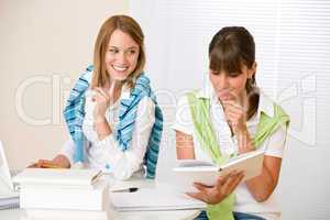 Student at home - two woman with book and laptop