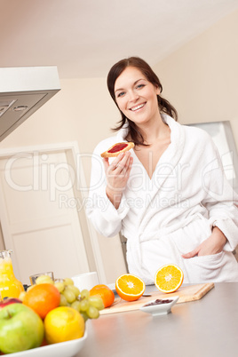 Young woman eating toast for breakfast in kitchen