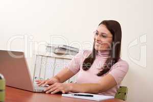 Smiling businesswoman with laptop at office