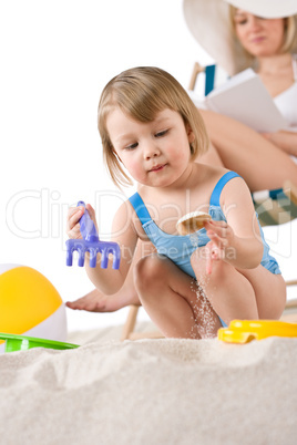 Beach - Mother with child playing with toys in sand