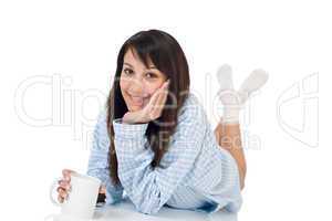 Happy young woman with coffee in pajamas
