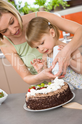 Mother and child with chocolate cake in kitchen