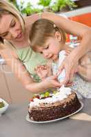 Mother and child with chocolate cake in kitchen