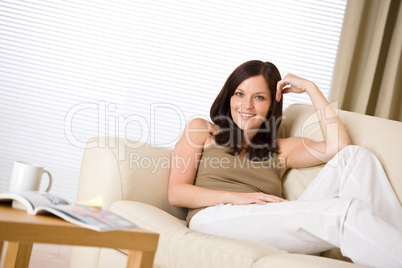 Young woman with magazine and coffee in lounge