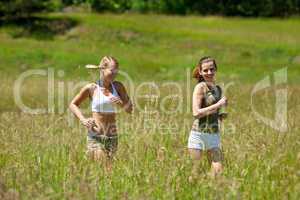 Two young woman jogging in a meadow