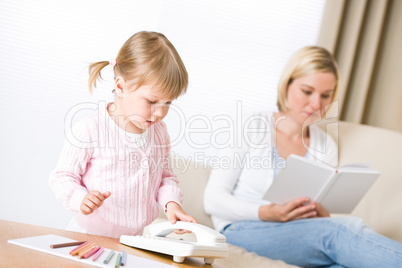 Little girl with phone in living room