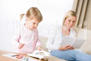 Little girl with phone in living room