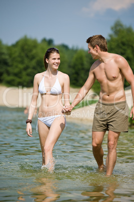 Happy couple in swimwear enjoy sun in lake