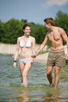 Happy couple in swimwear enjoy sun in lake