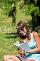 Happy young woman with book in park