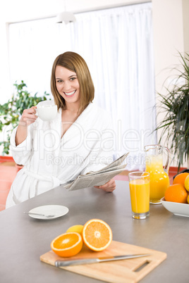 Breakfast - Smiling woman reading newspaper in kitchen