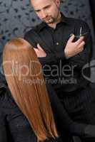 Professional hairdresser with fashion model at luxury salon