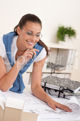 Smiling female architect watching plans
