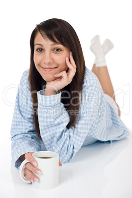 Happy young woman with coffee in pajamas