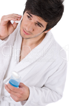 Facial care - Young man cleaning face with lotion