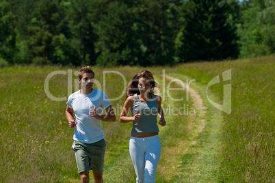 Young couple jogging outdoors in spring nature