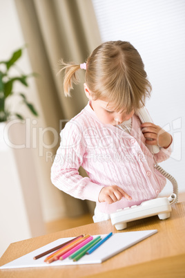 Little girl dial number on phone in lounge