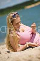 Beautiful blond woman playing with sand