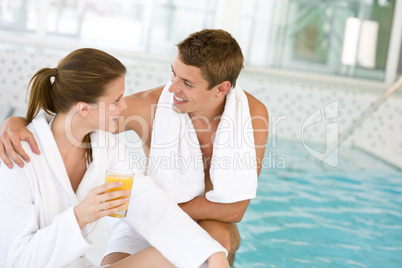 Young happy couple relax at swimming pool