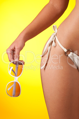 Part of female body with bikini and sunglasses