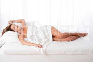 White lounge - Long shot of woman lying in bed