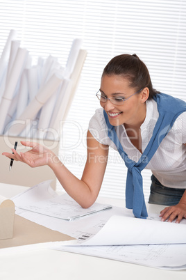 Smiling female architect watching plans