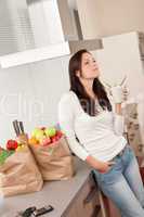 Young woman with groceries in the kitchen
