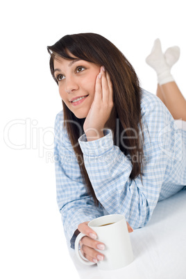 Happy young woman with coffee in pajamas