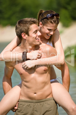 Piggyback - happy couple enjoy sun in nature