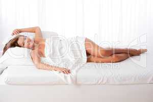 White lounge - Long shot of woman lying in bed