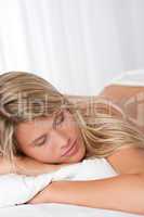 White lounge - Young blond woman lying in white bed